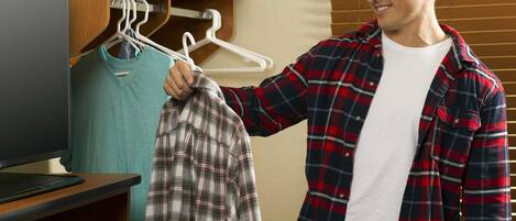 A person holding a plaid shirt in front of a television.