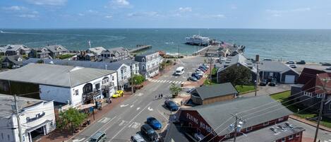 A coastal town with a prominent white building labeled "Strand Hotel" and a red building with "Flying Horses" signage.