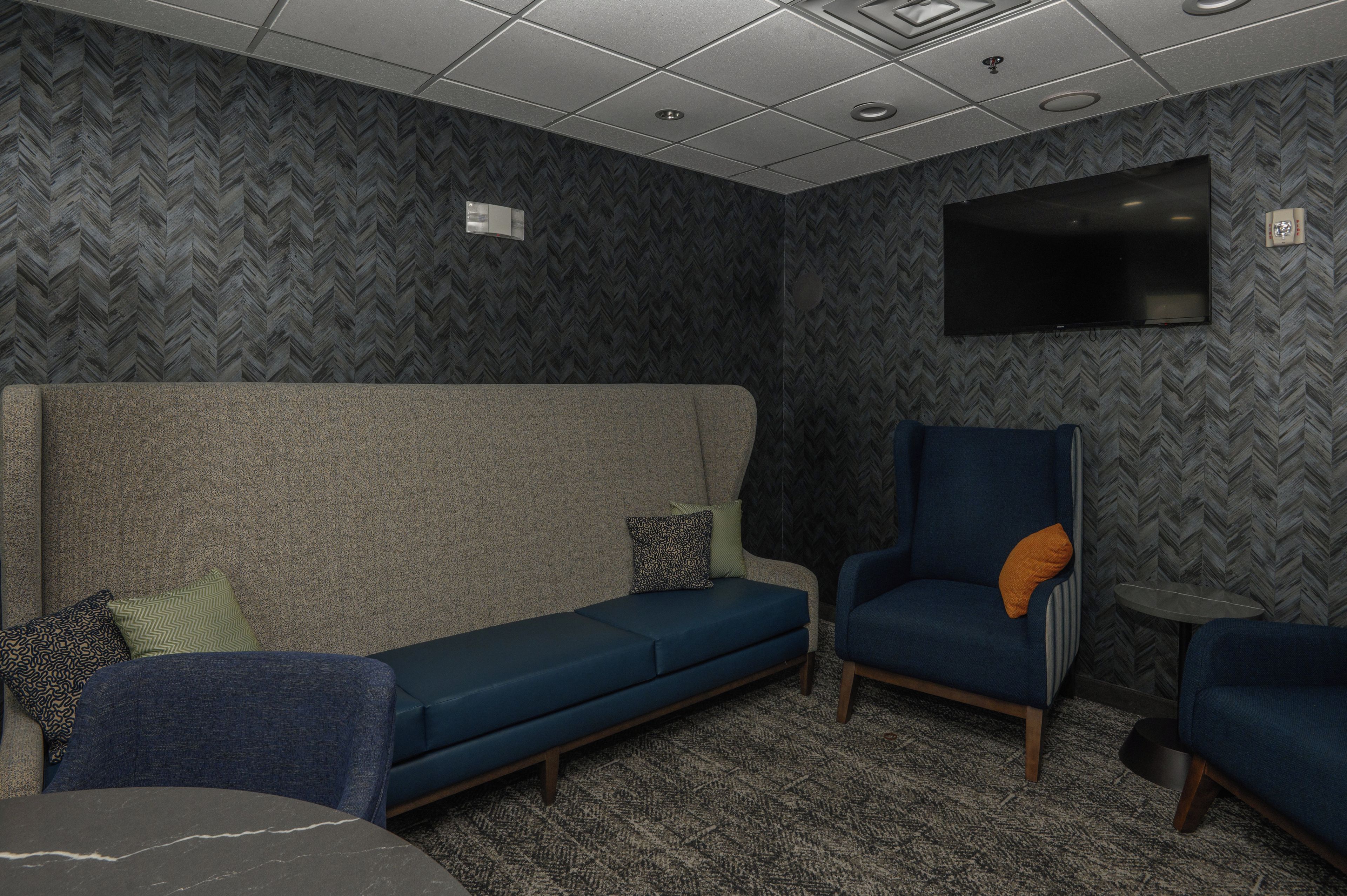 Una habitación con sofá, sillón y una pequeña mesa.