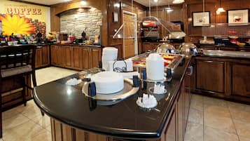 A buffet area with a variety of food items and a coffee station.