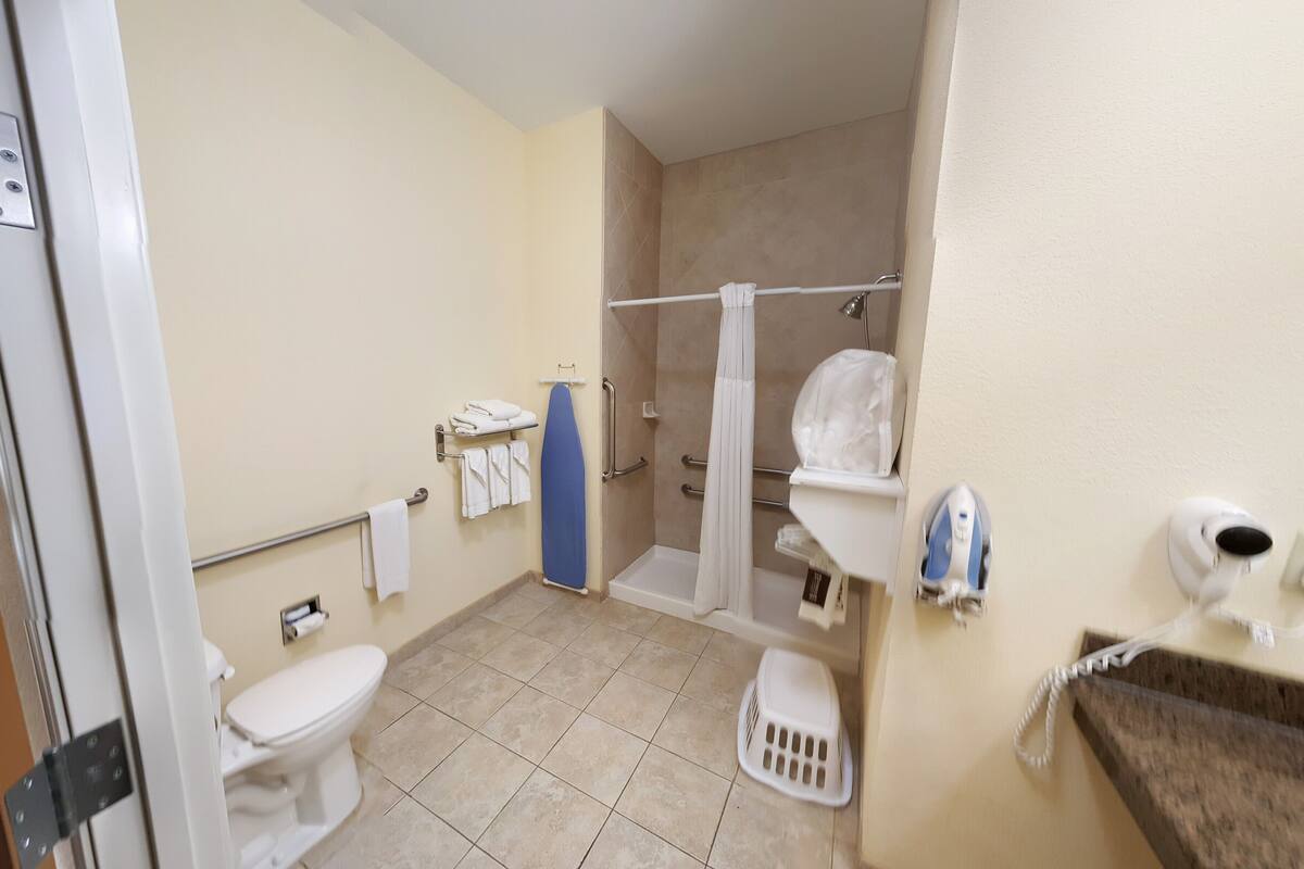 Une salle de bain équipée de toilettes, d’une douche et d’un lavabo avec un porte-serviettes.