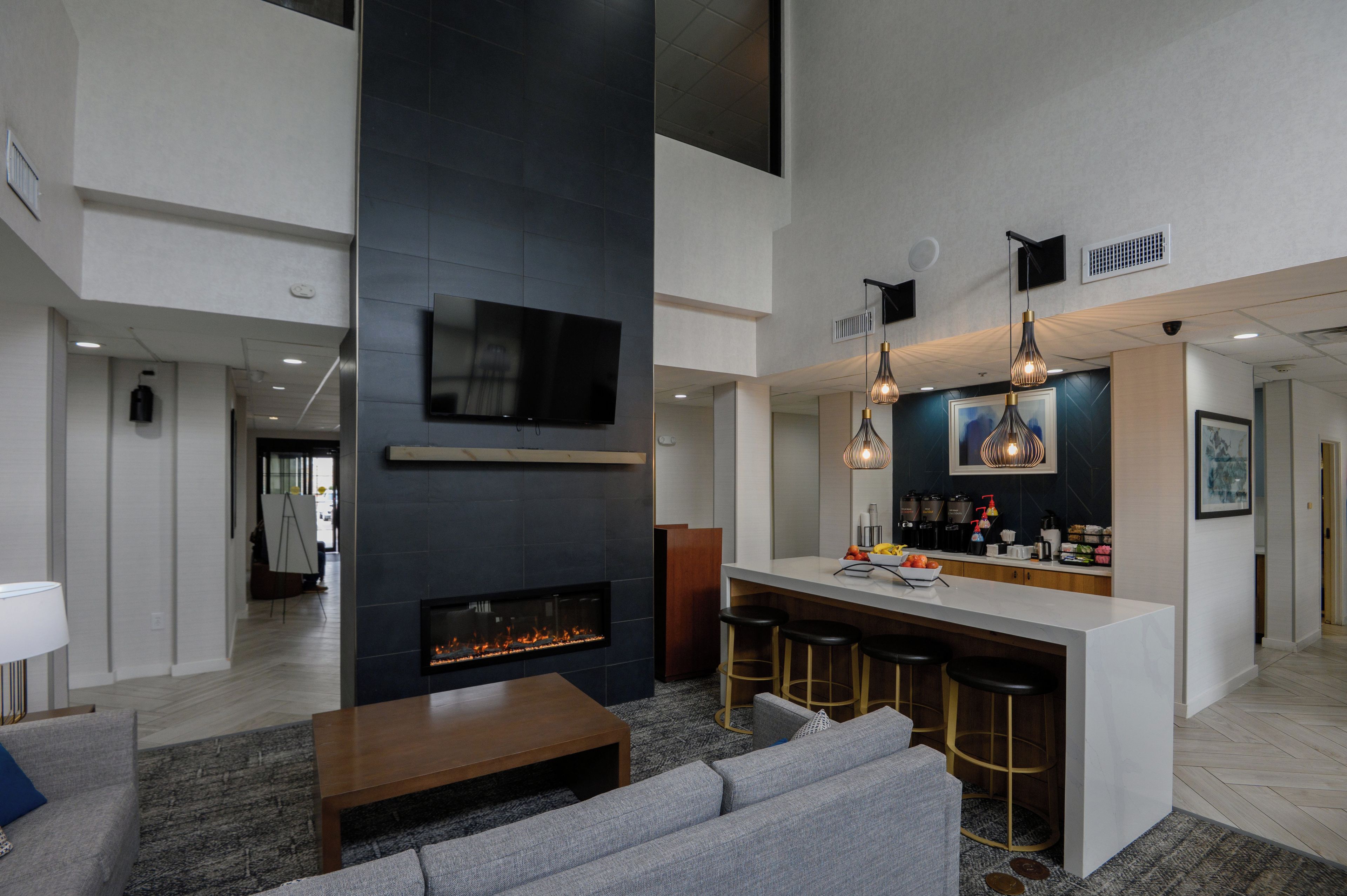 Un interior moderno con chimenea, zona de bar y asientos.