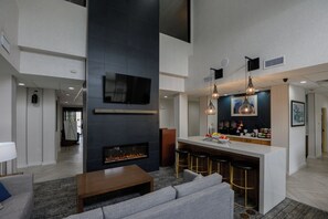 A modern interior with a fireplace, bar area, and seating. - Staybridge Suites Corpus Christi by IHG (Corpus Christi)