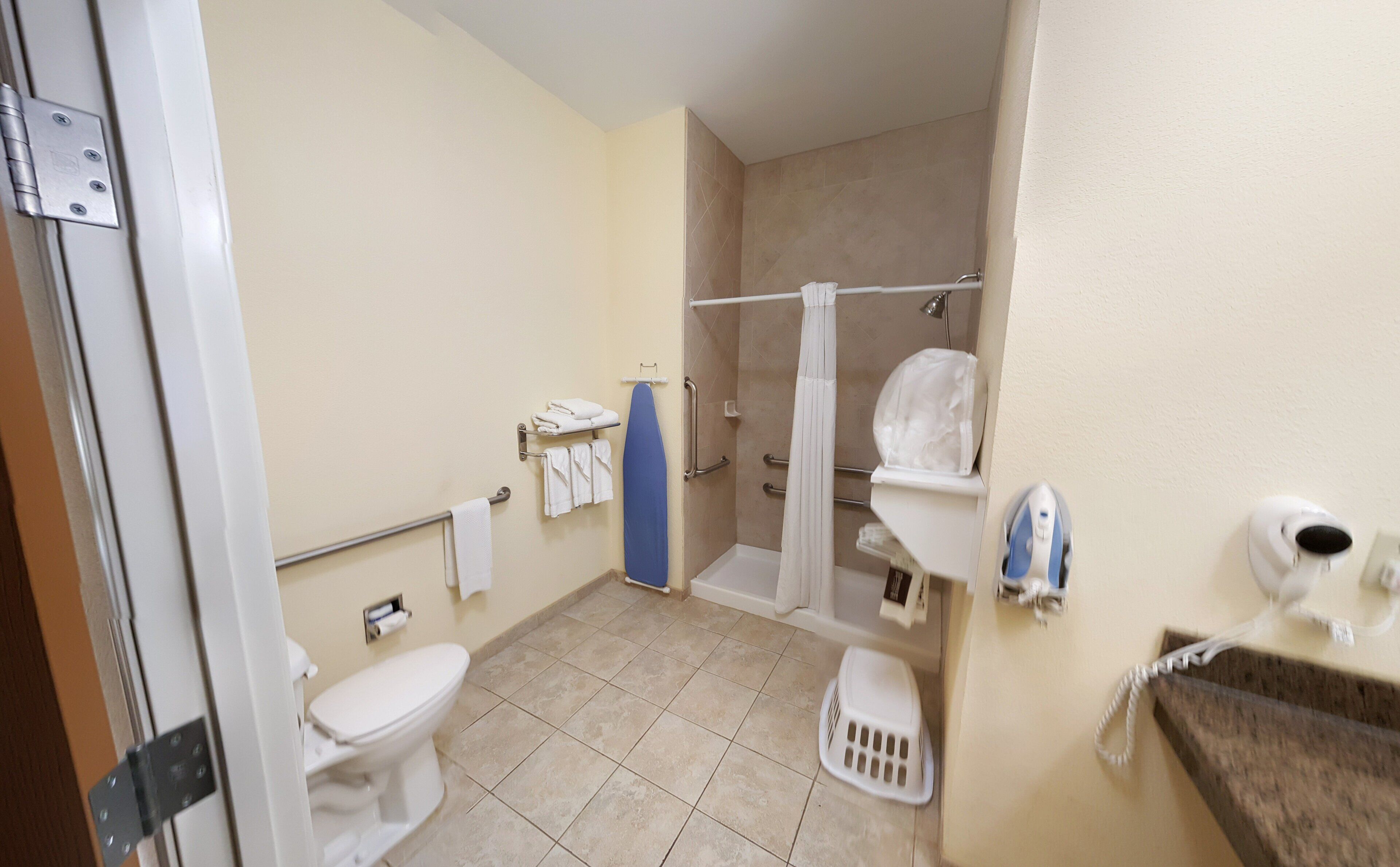 A bathroom with a toilet, shower, and a towel rack.