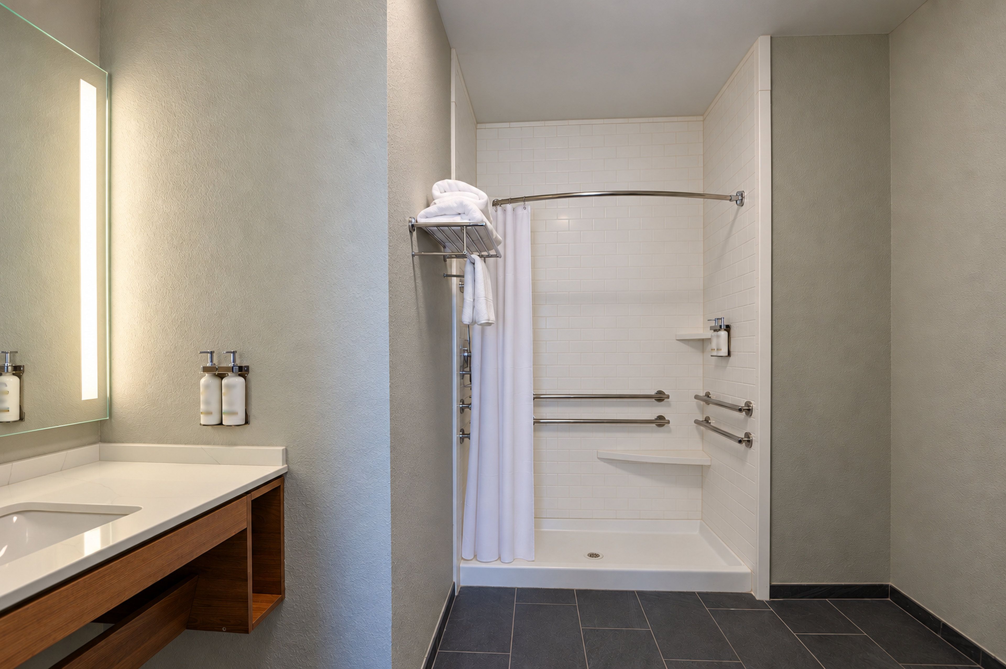 Une salle de bain moderne avec une douche, un lavabo et un miroir.