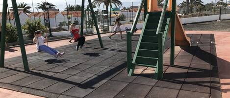 A playground with swings and a slide.