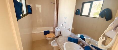 Une salle de bain avec une baignoire, des toilettes et un lavabo.