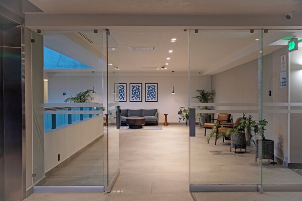A modern lobby with a reception desk, seating area, and potted plants. - Holiday Inn Express Guadalajara Expo by IHG (Guadalajara)