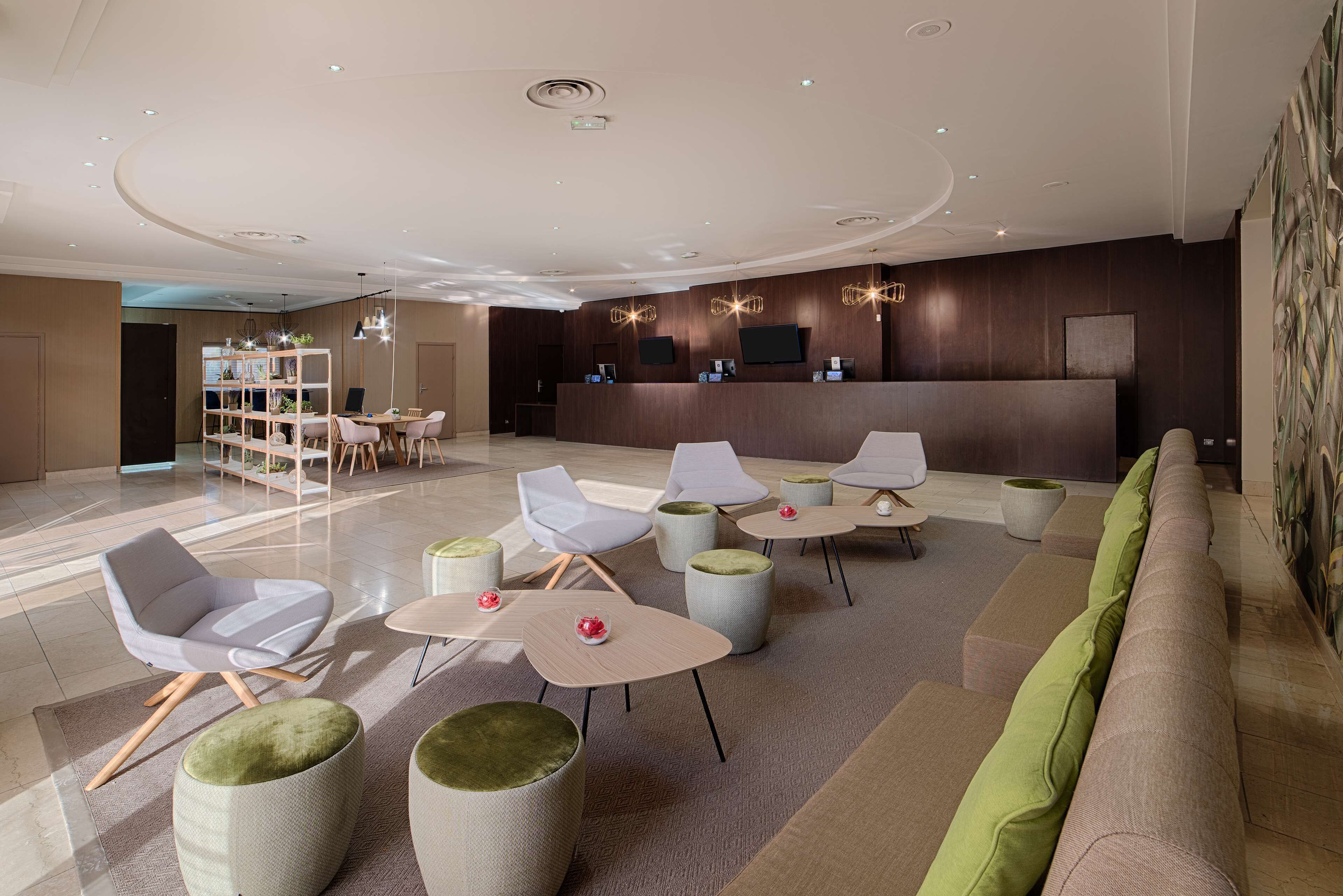 A modern lobby with a reception desk, seating area, and a bookshelf.
