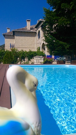 Una piscina al aire libre, sillones reclinables de piscina