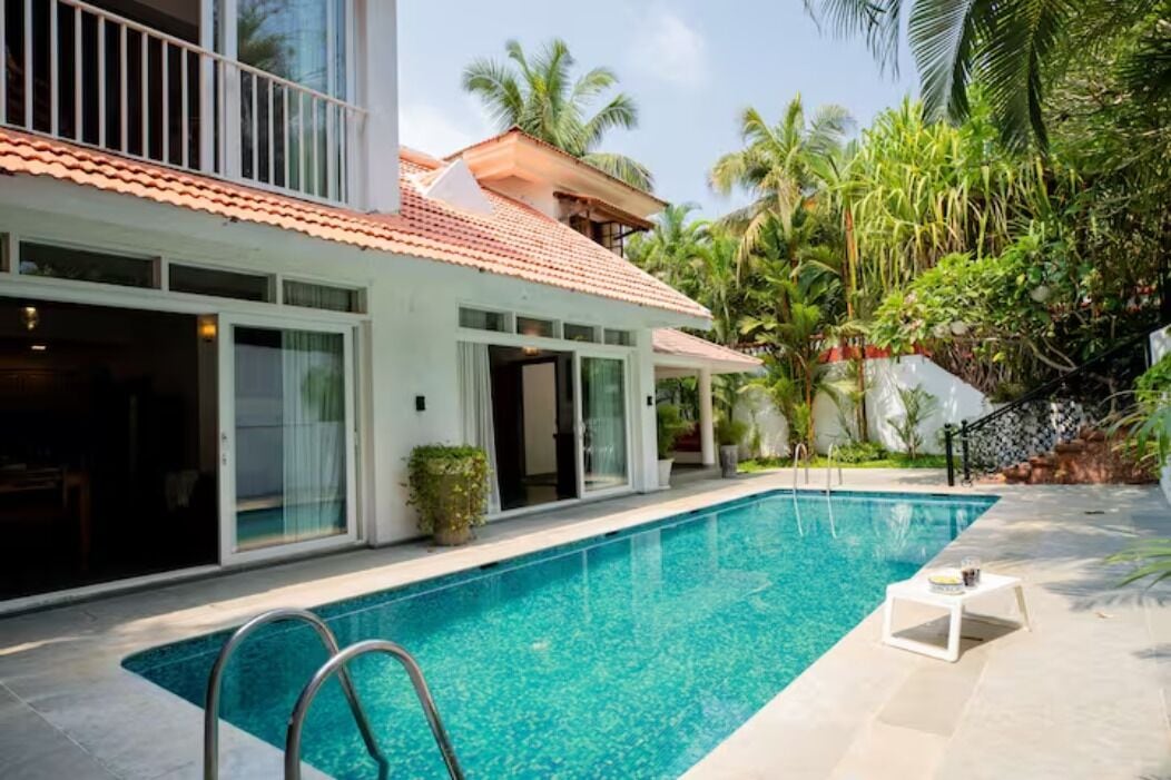A modern house with a swimming pool, large windows, and a balcony.