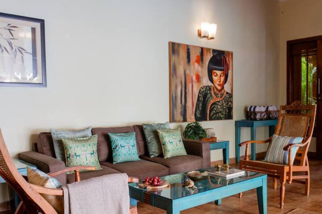 Un salon avec un canapé marron, une table basse en verre et une chaise en bois.