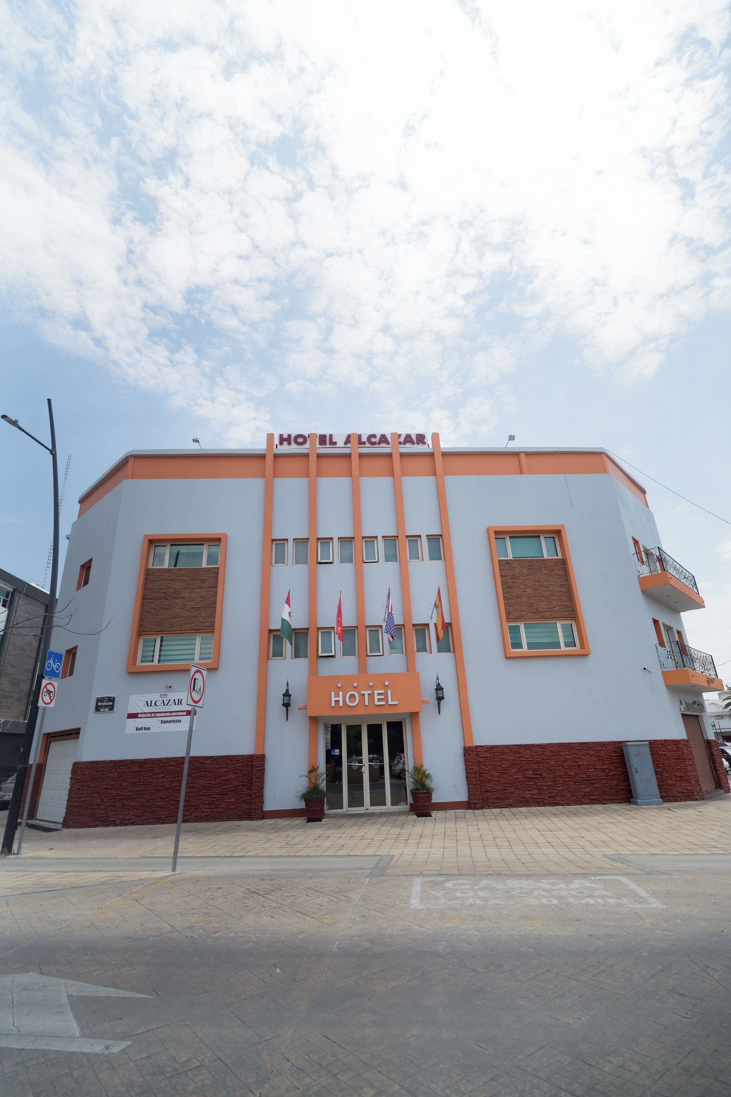 Ein Hotel mit moderner Fassade, mehreren Flaggen und einem markanten Eingang.