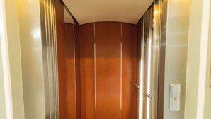 An elevator with a wooden interior and a digital display at the top. - Hotel Alcazar (Guadalajara)