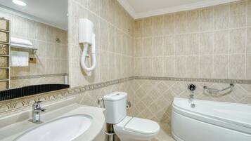 A bathroom with a sink, toilet, and bathtub.