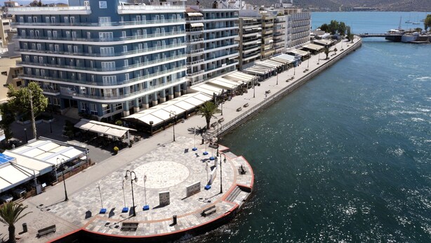 A waterfront hotel with a circular plaza, multiple balconies, and a view of the sea. - Paliria Hotel (Chalcis)