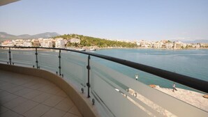 A balcony with a view of a waterfront cityscape, including buildings and a distant hill. - Paliria Hotel (Chalcis)
