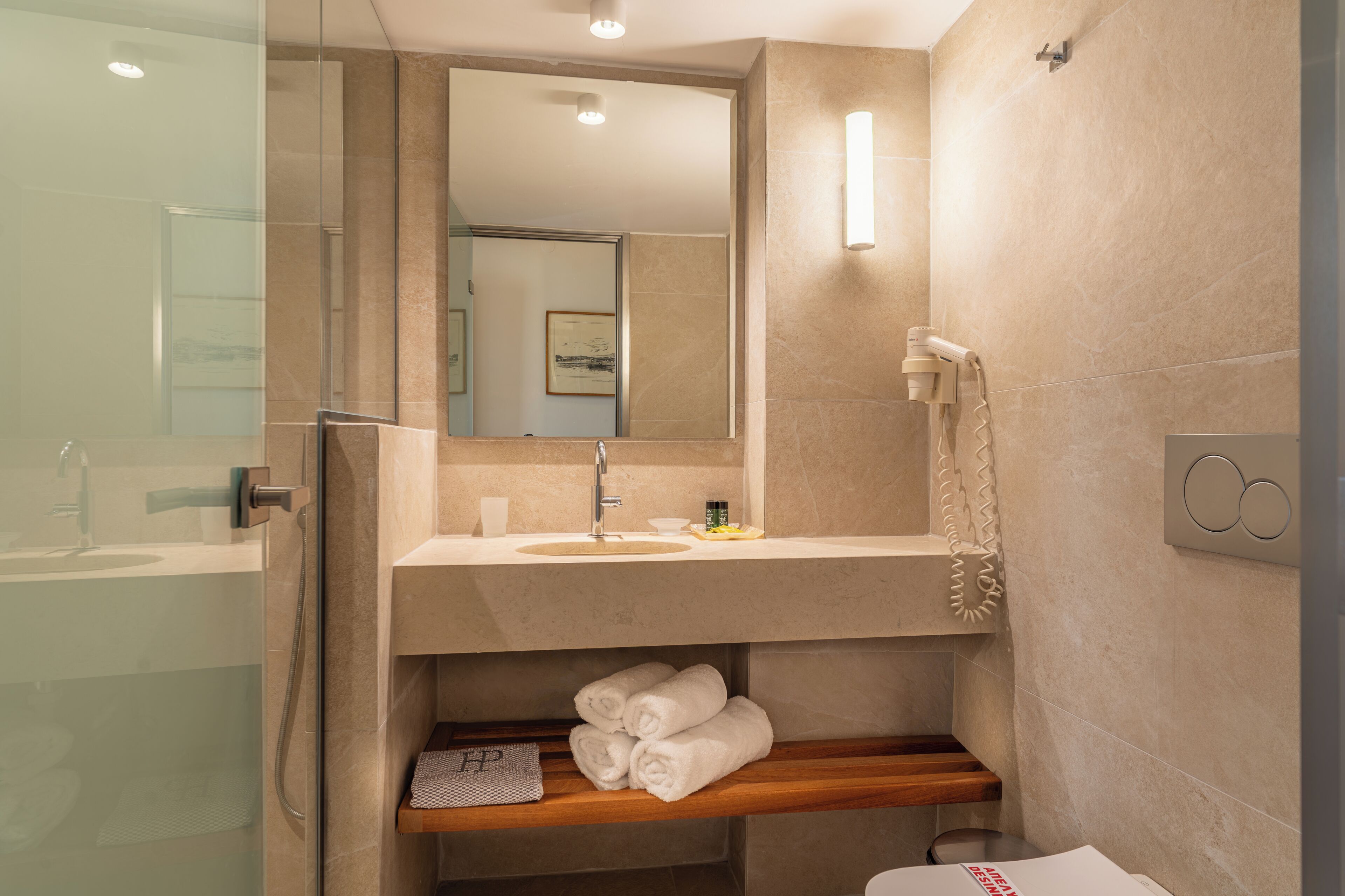 Un bagno moderno con cabina doccia in vetro, un lavabo con mobile e un porta asciugamani.