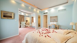 A bedroom with a large bed, a desk, a chair, and a bathroom. - Paliria Hotel (Chalcis)