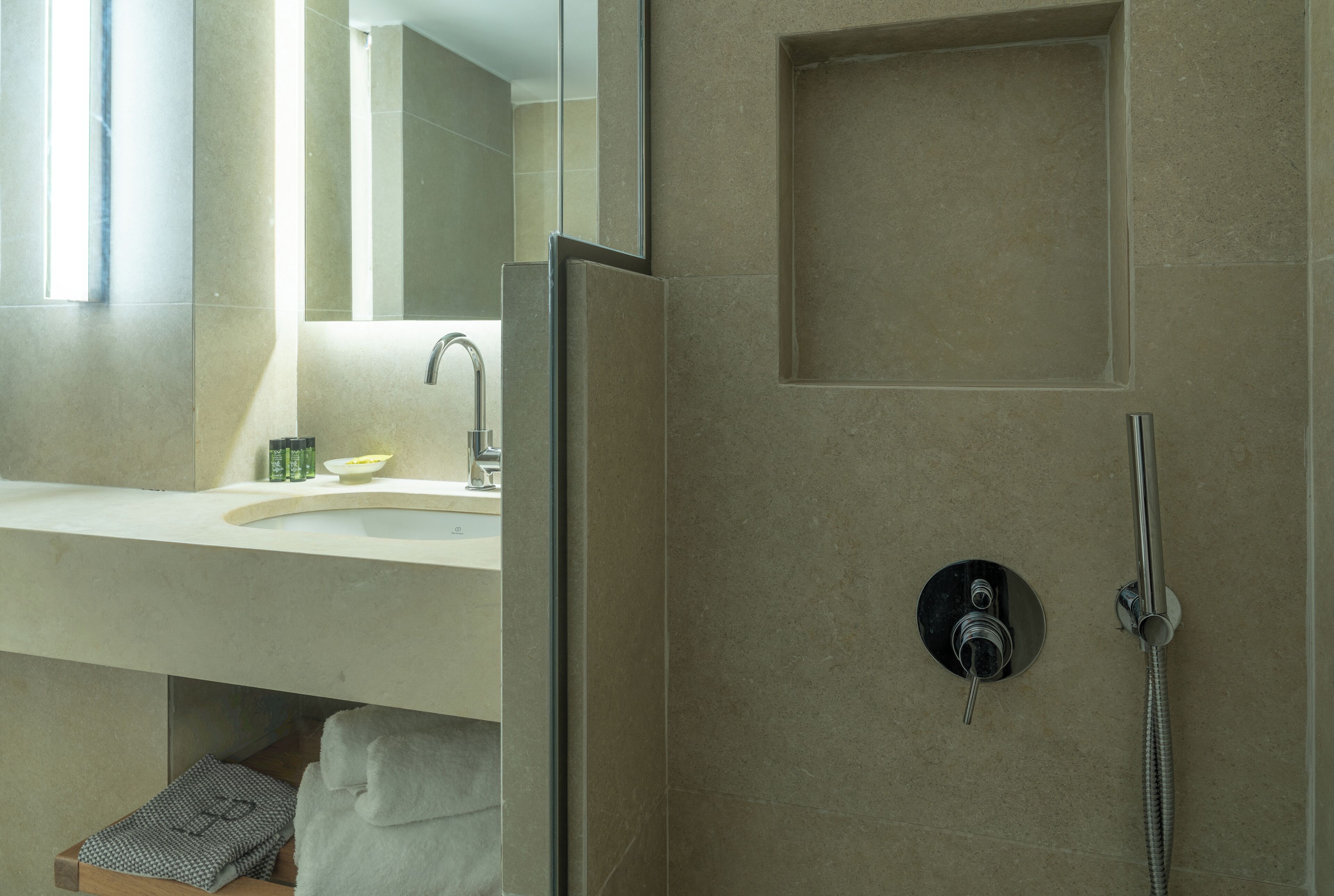 A modern bathroom with a shower, a sink, and a mirror.