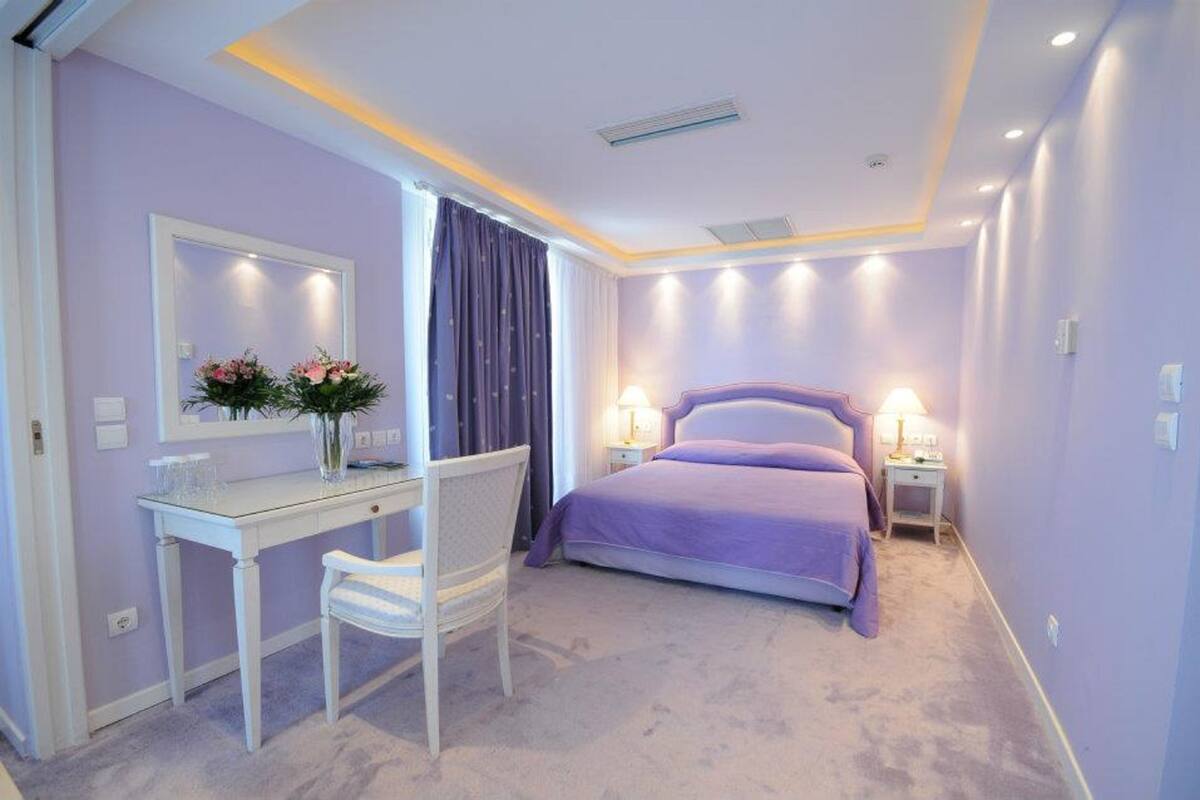 Ein Schlafzimmer mit einem Bett, Nachttischen, einem Schreibtisch und einem Stuhl.