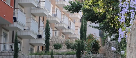 Una escalera de piedra que conduce a un edificio residencial con varios balcones.