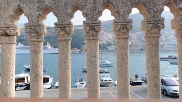 A view through stone arches with boats docked in the background.