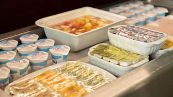 A display of various food items including yogurt, cheese, and a fruit salad.