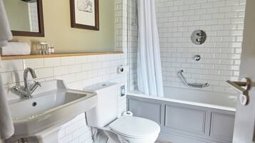 Un baño con lavamanos, inodoro y bañera.