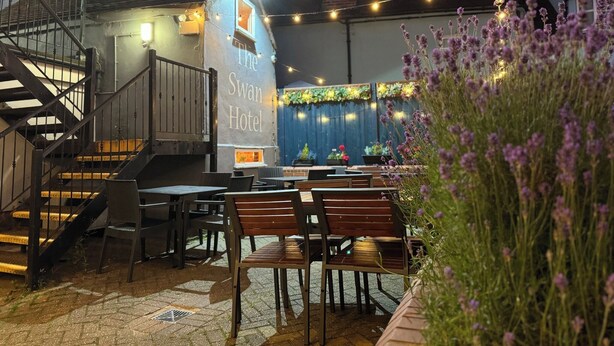 An outdoor seating area with tables and chairs, a staircase, and a building labeled "The Swan Hotel." - Swan Hotel Thaxted by Greene King Inns (Dunmow)