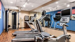 Une salle de sport équipée de tapis de course, de vélos elliptiques et de matériel de musculation.