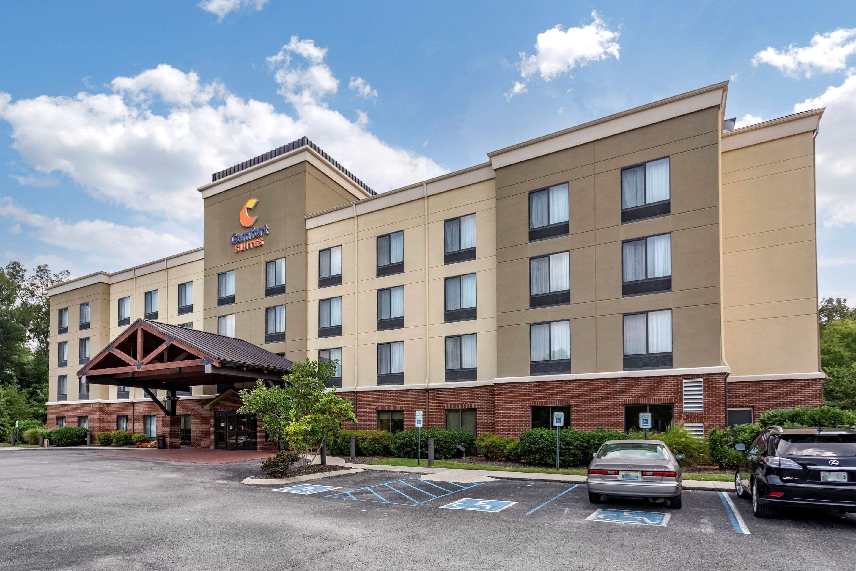 A Comfort Suites hotel with a brick facade, multiple windows, and a covered entrance.