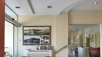 Step into a stylish lobby with a curved staircase, reception desk, and cozy seating area.