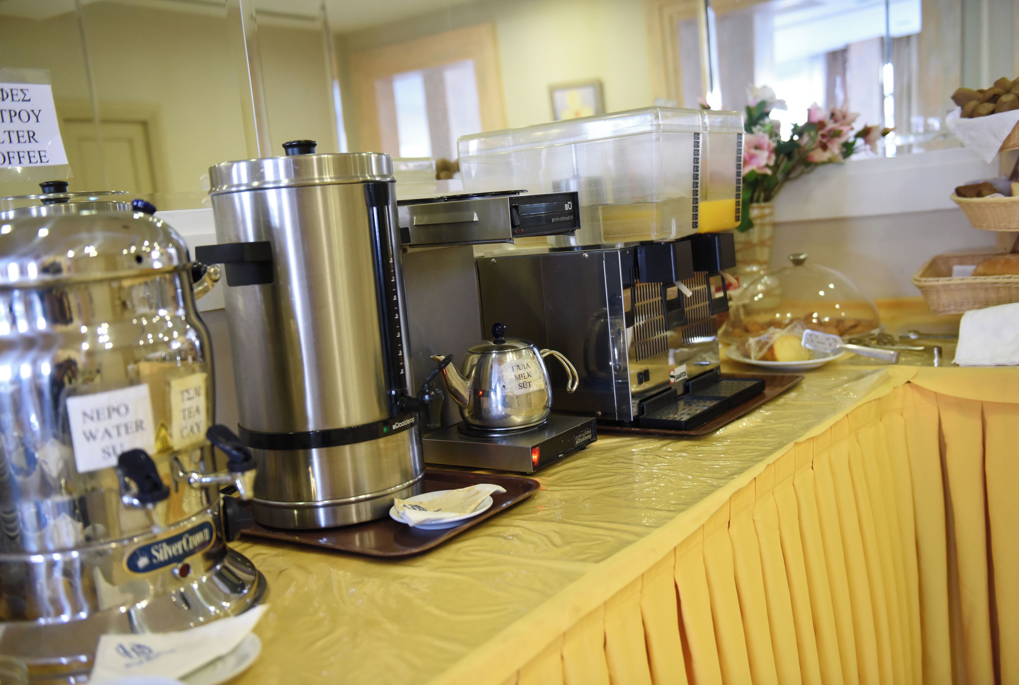 A coffee station with various brewing equipment and labeled containers.