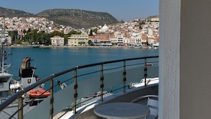 Un balcon offrant une vue sur un port, des bateaux et le paysage urbain.