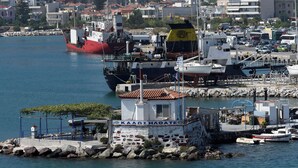 A harbor with boats, a dock, and a cityscape in the background. - Blue Sea (Lesvos)