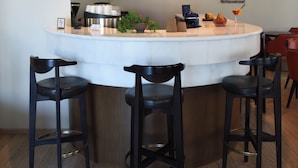 A modern kitchen with a central island, bar stools, and a built-in oven. - Blue Sea (Lesvos)