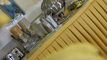 Una encimera de cocina con varios electrodomésticos y recipientes, incluyendo una cafetera, un tostador y botes de especias.