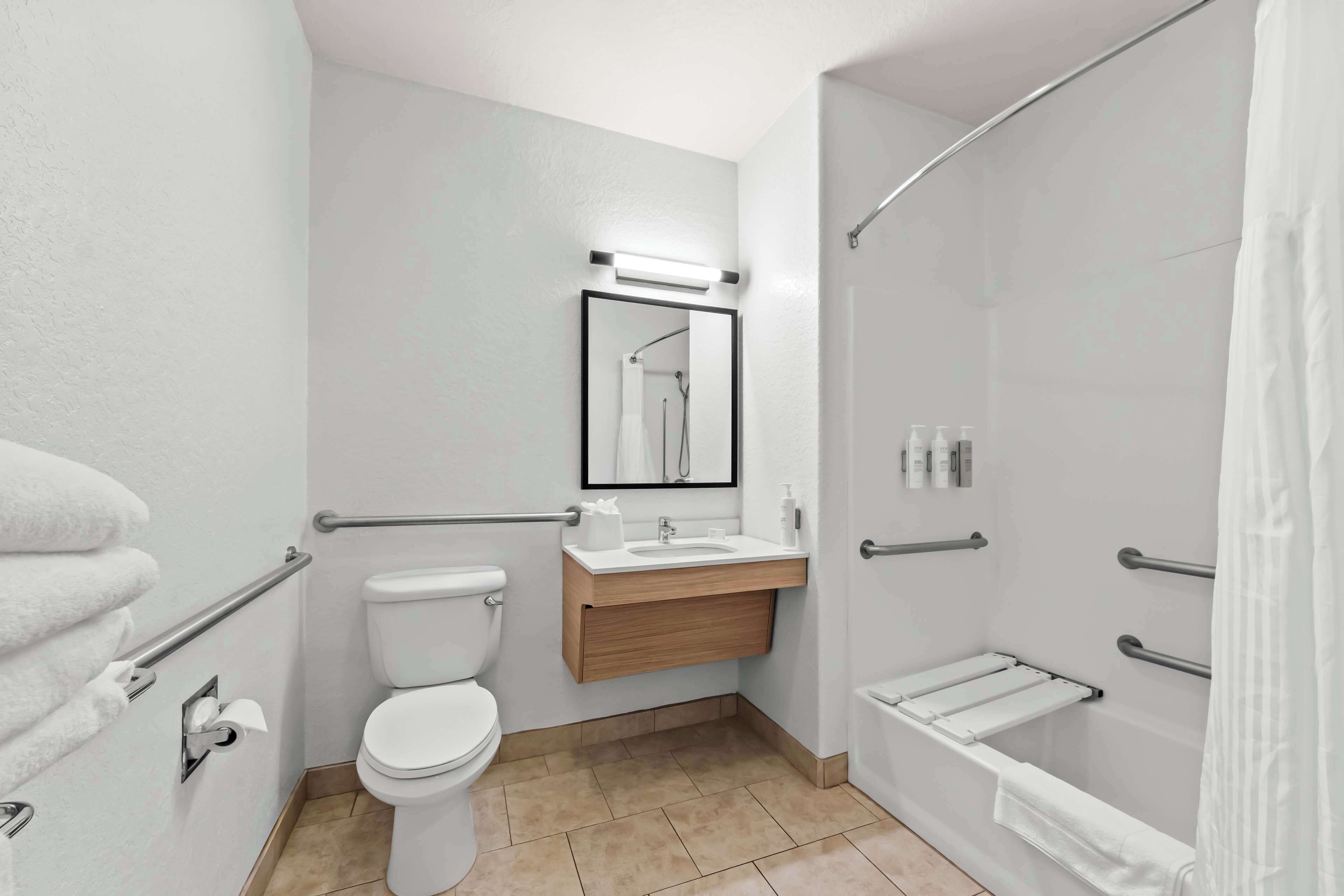 A modern bathroom with a toilet, sink, and shower.