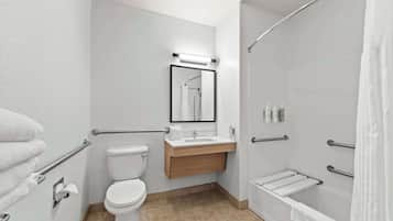 A modern bathroom with a toilet, sink, and shower.