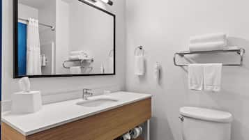 A modern bathroom with a white sink, a mirror, a toilet, and a towel rack.