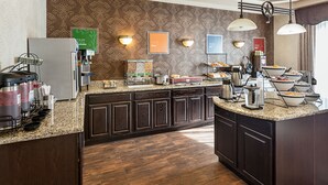 A modern kitchen with a granite countertop, dark wood cabinets, and a patterned backsplash. - Spark by Hilton San Antonio near SeaWorld (San Antonio)