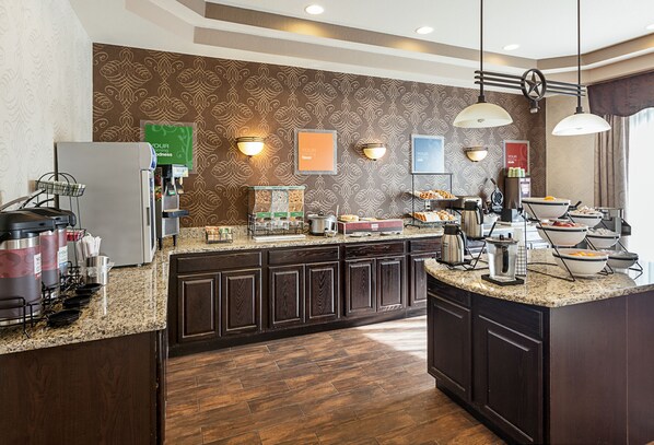 A modern kitchen with a granite countertop, dark wood cabinets, and a patterned backsplash. - Spark by Hilton San Antonio near SeaWorld (San Antonio)