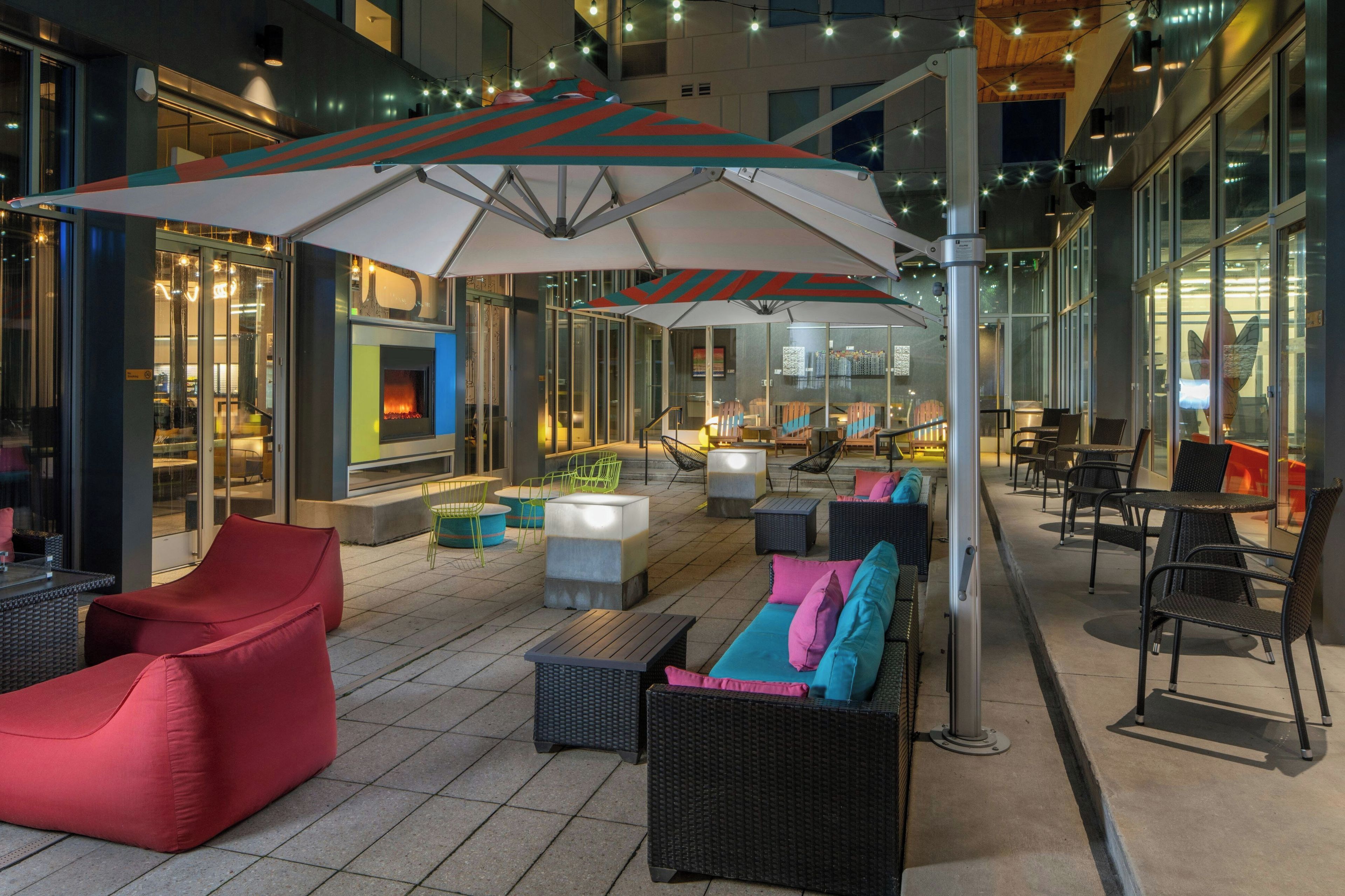 Een terras met moderne meubels en een vuurplaats.