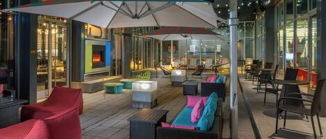 Een terras met moderne meubels en een vuurplaats.