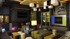 Ein moderner Lounge-Bereich mit Sofas, Poufs und einem Kamin.