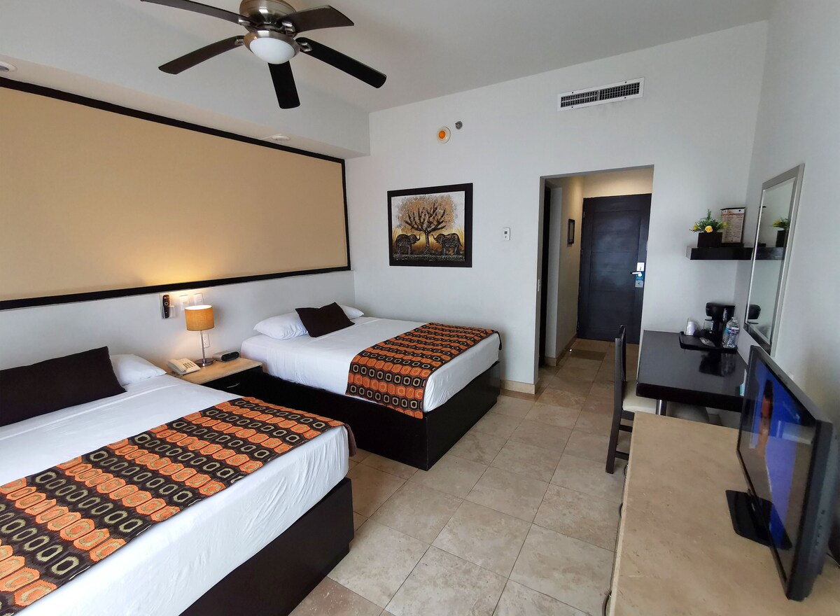 Habitación, 2 camas matrimoniales, vista parcial al océano | Caja de seguridad en la habitación y decoración personalizada 