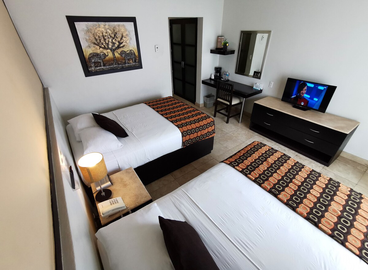 Habitación, 2 camas matrimoniales, vista parcial al océano | Caja de seguridad en la habitación y decoración personalizada 