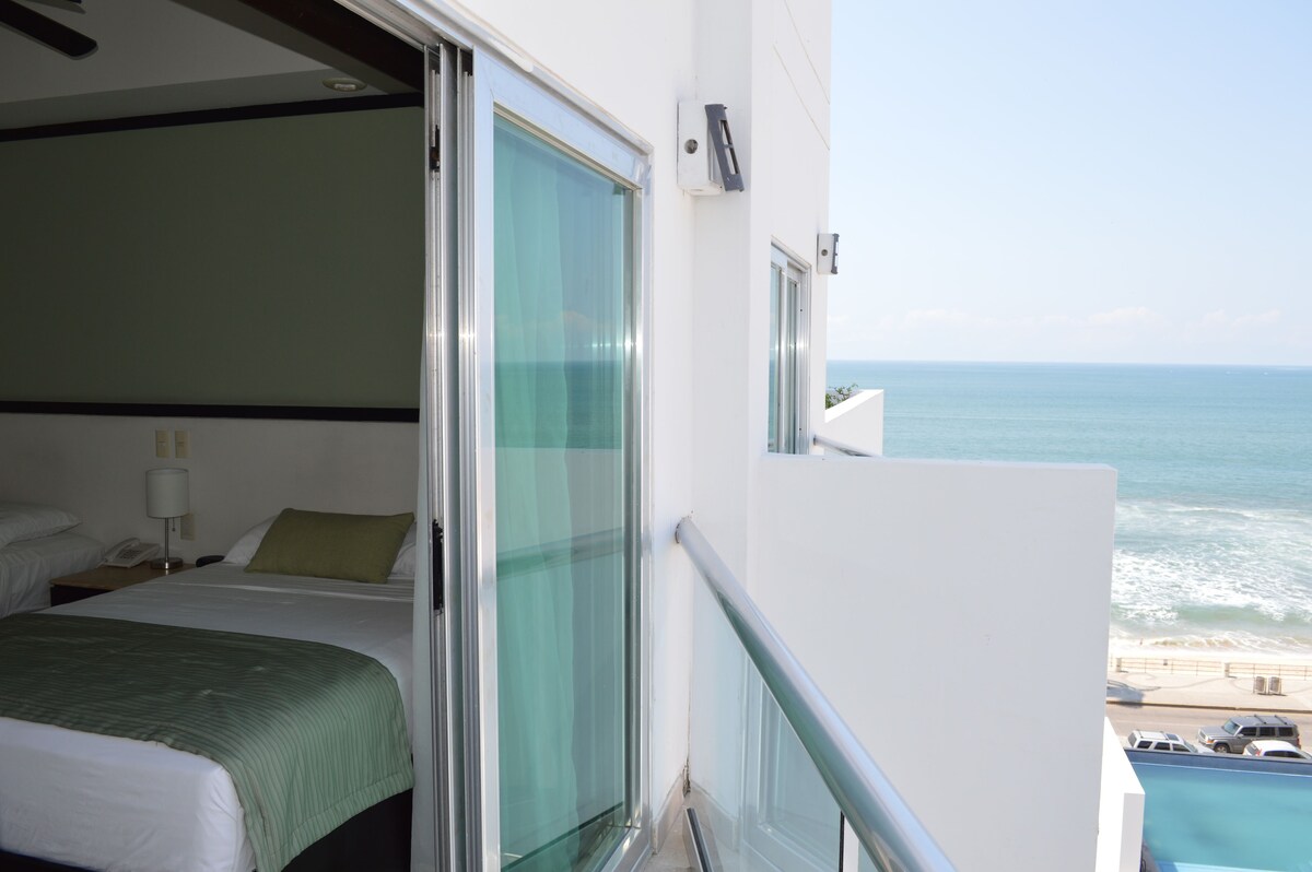 Habitación, 2 camas matrimoniales, vista parcial al océano | Vista desde la habitación