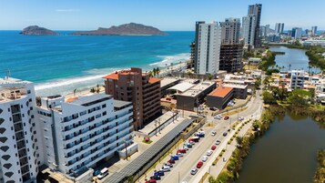Un paisaje urbano costero con rascacielos, una playa y un río.